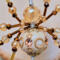 Fantasy-inspired gold and cream spider ornament made with crystal beads and wrapped wire legs